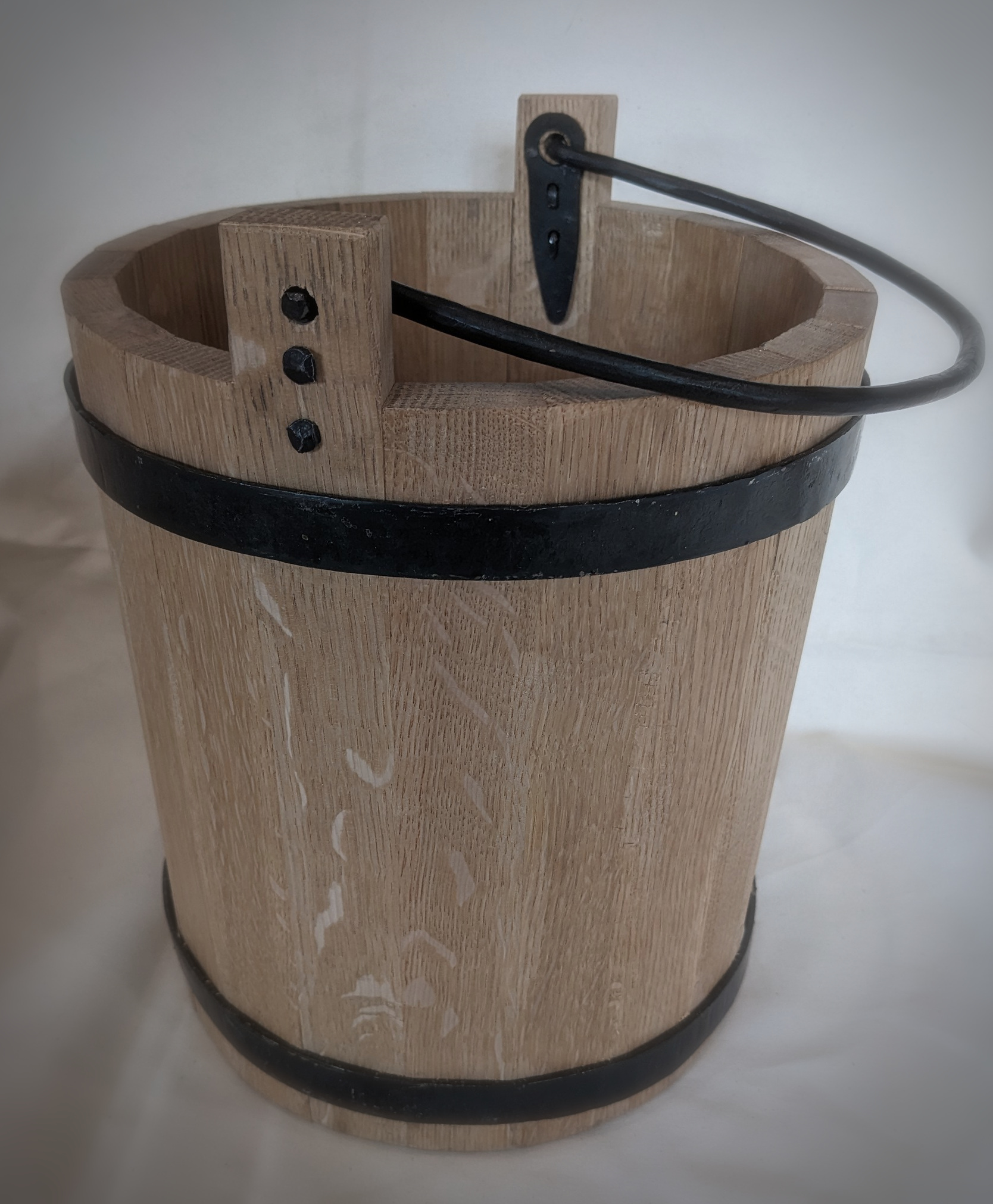 Wooden bucket with metal hoops and handle